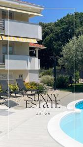 a sign for a resort with chairs and a swimming pool at Sunny Apartments in Zaton