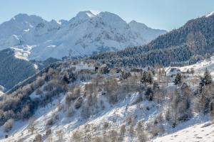 un complejo en una montaña nevada con una montaña en Un appartement coquet au pied des pistes, en Val Louron