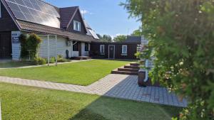 uma casa com um quintal com uma casa com um relvado em Tiigi Accommodation em Kärdla