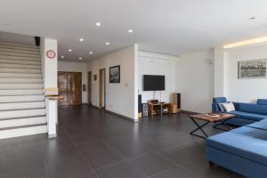 a living room with blue couches and a tv at Luxury Villa a unique Paradise directly on the Sea in Mormol