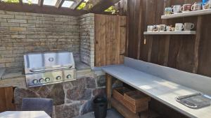 an outdoor kitchen with a stove and a bench at Tiigi Accommodation in Kärdla