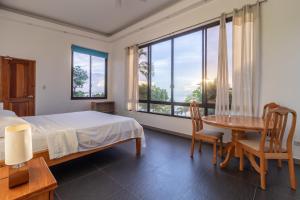 a bedroom with a bed and a table and a window at Luxury Villa a unique Paradise directly on the Sea in Mormol +30 photos