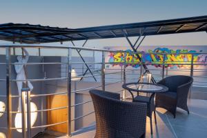a balcony with chairs and a table on a ship at Clubway Grand A Boutique Hotel in Jorhāt