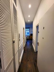 a hallway with wooden floors and white walls and doors at Stylowy apartament - Stare Miasto Hvile Stay in Toruń