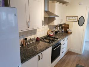 a kitchen with white cabinets and granite counter tops at Big Private Room In Town Centre in Eastleigh