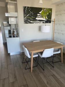 ein Esszimmer mit einem Holztisch und weißen Stühlen in der Unterkunft Luxurious Resorts in Pretoria