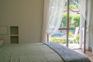 a bedroom with a bed and a large window at Casa Hemingway - WelcHome in Stresa