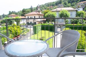 a table and chairs on a balcony with a view at Casa Hemingway - WelcHome in Stresa