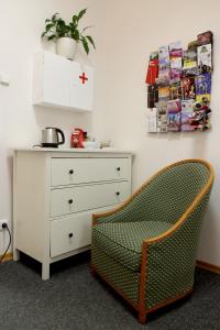 um quarto com uma cómoda e uma cadeira ao lado de uma gaveta em Hostel Franz Kafka em Praga