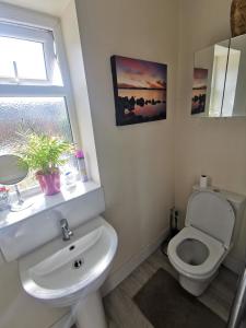 a bathroom with a toilet and a sink and a window at Big Private Room In Town Centre in Eastleigh