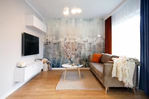 - un salon avec un canapé et une table dans l'établissement W&K Apartments - Harmony Suite, à Koszalin