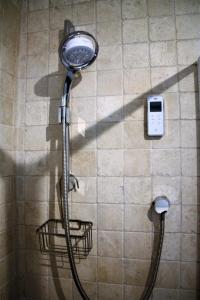 a shower with a shower head on a wall at The Roost - Askrigg 18th Century Cottage in Askrigg