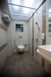 a bathroom with a toilet and a sink and a shower at Hotel Naaz Executive in Mumbai