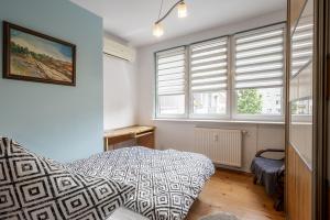 a bedroom with a bed and two windows at 17 Gdynia Centrum - Apartament Mieszkanie dla 4 os in Gdynia