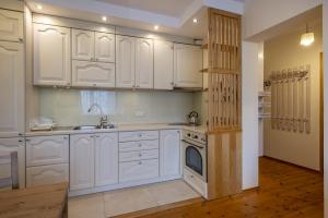 a kitchen with white cabinets and a sink and a dishwasher at 17 Gdynia Centrum - Apartament Mieszkanie dla 4 os in Gdynia