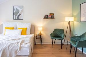 a bedroom with a bed and two green chairs at Familienwohnung im Vogtland in Lengenfeld