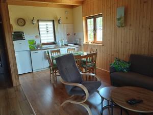 a kitchen and living room with a table and a couch at Wakacyjny Łebcz in Łebcz