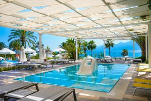 a pool at a resort with tables and chairs at Akra Antalya in Antalya