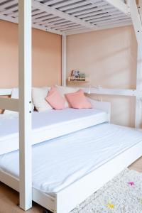 a bedroom with two bunk beds with pink pillows at Familienwohnung im Vogtland in Lengenfeld