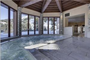 a large swimming pool in a house with windows at ARC 1950 Appt 6/8 pers LUXE MANOIR SAVOIE - SKI IN SKI OUT in Arc 1950
