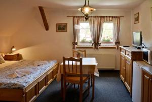 a room with a table and a bed and a window at Penzion Lesní Zátiší in Horní Malá Úpa