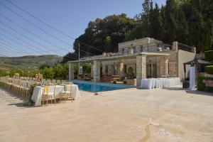 a venue with tables and chairs in front of a building at Villa Mantilari Wine Estate 7 Apartments 2 Private Pools 1 Heated Tennis Court Fitness Center in Archanes