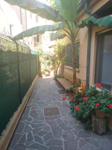 a patio with a bench and flowers in a courtyard at Ampio monolocale nel cuore di Pesaro in Pesaro