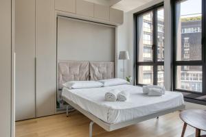 - une chambre avec un lit doté de draps et d'oreillers blancs dans l'établissement JOIVY Chic studio close to Central Tower, à Milan