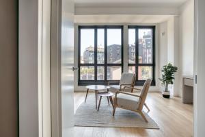 d'un salon avec une table, des chaises et une fenêtre. dans l'établissement JOIVY Chic studio close to Central Tower, à Milan