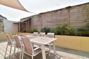 ein weißer Tisch und Stühle auf einer Terrasse in der Unterkunft La Paillotte - à 7min de la plage in Beaussais sur Mer