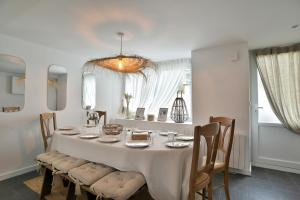 ein Esszimmer mit einem weißen Tisch und Stühlen in der Unterkunft La Paillotte - à 7min de la plage in Beaussais sur Mer + 8 Fotos