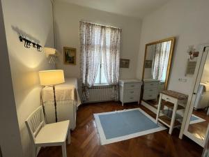 1 dormitorio con cama, silla y espejo en Guest House Ilicki Plac, en Zagreb
