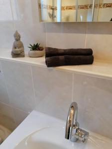 łazienka z umywalką i ręcznikiem na półce w obiekcie Weinstrassenblick w mieście Burrweiler