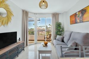 a living room with a couch and a tv at Vistamarina A309 By IVI Real Estate in Torremolinos