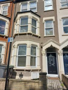 a large brick house with a black door at White Hart Lane walking distance Tottenham Hotspur Stadium in London +2 photos