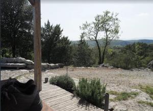 um par de sapatos sentados num alpendre com vista para um campo em Les Faveyrolles à Labeaume em Labeaume