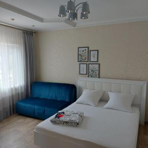 um quarto com uma cama e um sofá azul em 2кк люкс 3-я Слободская/Кузнецкая em Mykolaiv