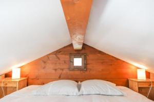 Bett in einem Zimmer mit einer Holzwand in der Unterkunft Mazot de l'Ours - Happy Rentals in Chamonix-Mont-Blanc