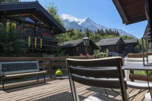 eine Terrasse mit einem Tisch, Stühlen und einem Berg in der Unterkunft Mazot de l'Ours - Happy Rentals in Chamonix-Mont-Blanc