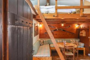 Cette chambre comprend une table et deux lits superposés. dans l'établissement Mazot de l'Ours - Happy Rentals, à Chamonix-Mont-Blanc