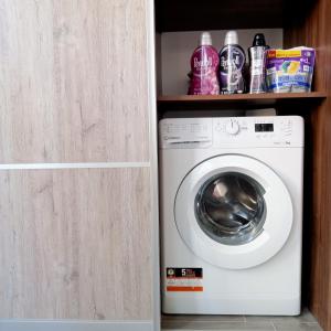 Una lavadora y secadora en un armario en Apartments Villa OLGA, en Leópolis