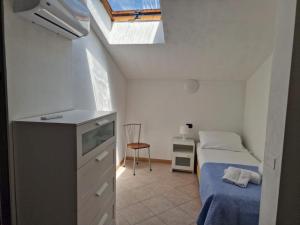 Habitación pequeña con cama y ventana en Villa La Cavaliera, en San Vincenzo