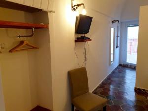 a room with a chair and a tv on a wall at Marbnb Appartamenti Ponza Centro porto Appartamento Cupola in Ponza