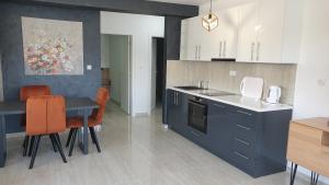 a kitchen with blue cabinets and a table with orange chairs at APARTMAN 5 BMB in Veliko Gradište