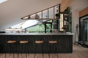 un bar con sgabelli in una stanza con finestra di Grand Pension Franziska - inkl CrossFit Gym a Saalbach Hinterglemm