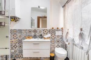 uma casa de banho com um WC, um lavatório e um espelho. em Oratoio Duplex Apartment with Parking em Pisa