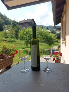 a bottle of wine sitting on a table with two glasses at Kuća za odmor "Mira" in Foča