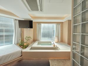 a bathroom with a tub in the middle of a room at UH Suite Seoul Square in Seoul