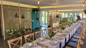 uma sala de jantar com uma mesa longa com cadeiras e flores em Akwamaryn Spa Niechorze em Niechorze