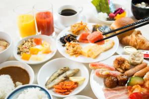 Grand Park Hotel Panex Iwaki في إيواكي: طاولة مليئة بأطباق الطعام والمشروبات
